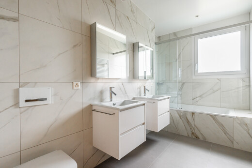 salle de bains avec mur en carrelage, tile wall, salle de bain complète, deux lavabos simples, et miroir