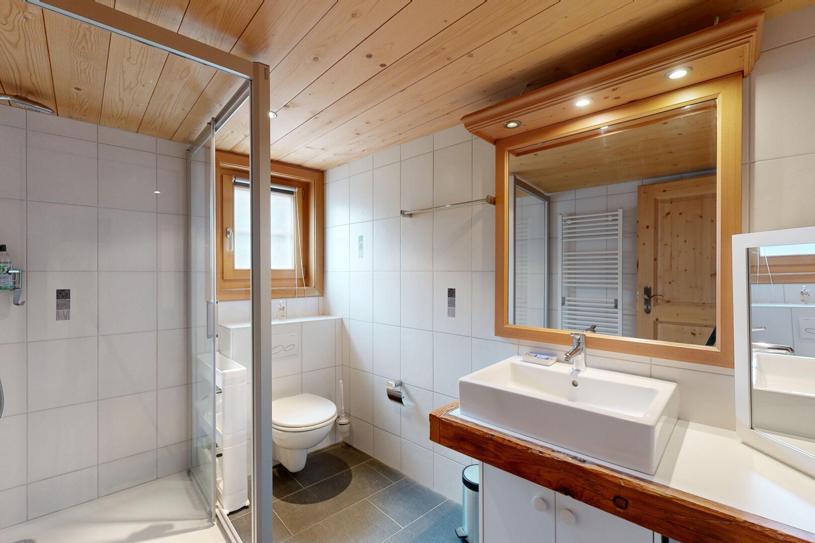salle de bains avec chauffe-serviettes, douche, salle de bain complète, évier, et sol en carrelage