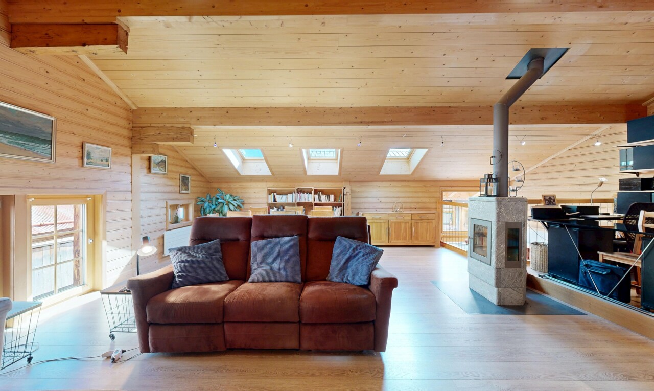 salon avec wood finish floor, sol en finition bois, vaulted ceiling, plafond voûté, et beamed ceiling
