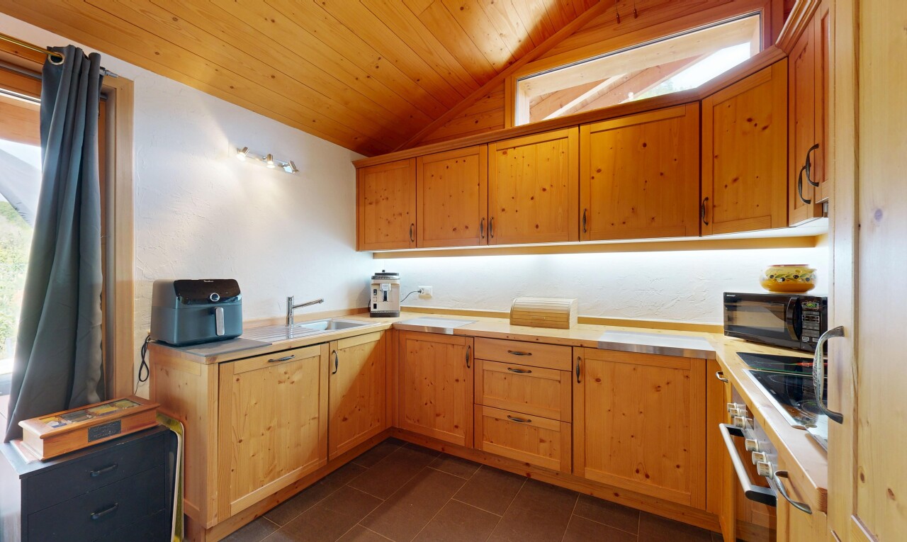 cuisine avec plafond en bois, wood ceiling, armoires avec moulures, crown molding cabinets, et plans de travail
