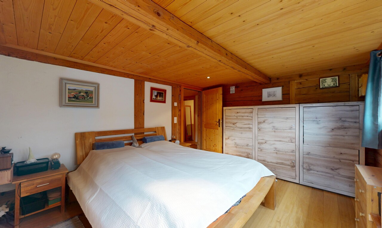 chambre avec sol en finition bois, wood finish floor, inside property, plafond à poutres, et beamed ceiling
