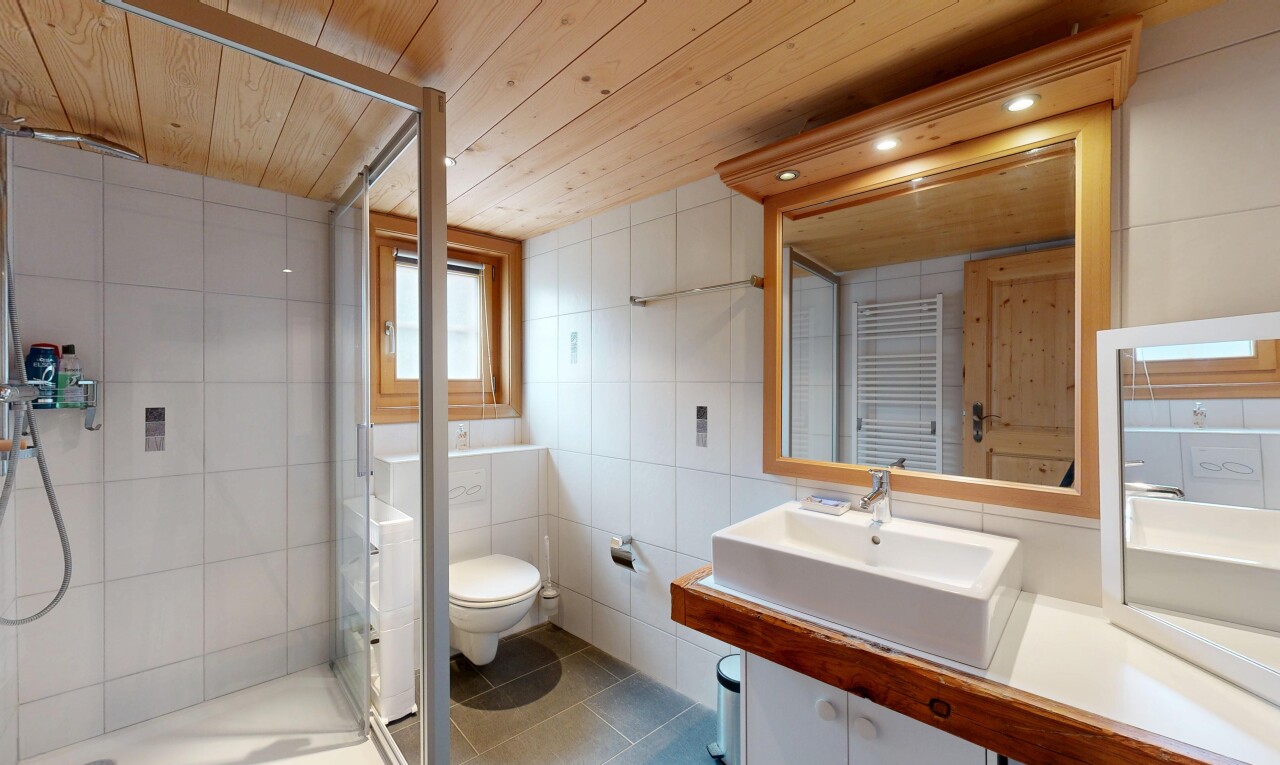 salle de bains avec chauffe-serviettes, douche, salle de bain complète, évier, et sol en carrelage