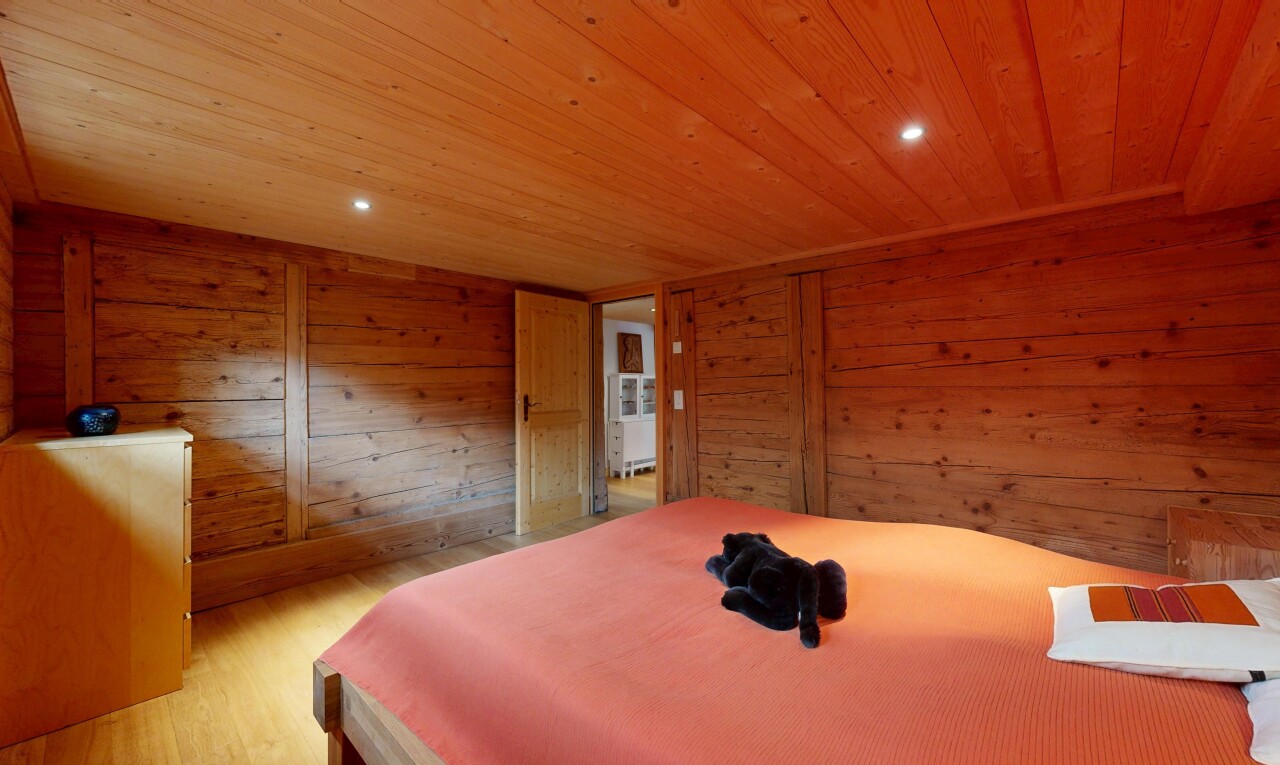 chambre avec wood finish floor, sol en finition bois, low ceiling, plafond bas, et wood wall