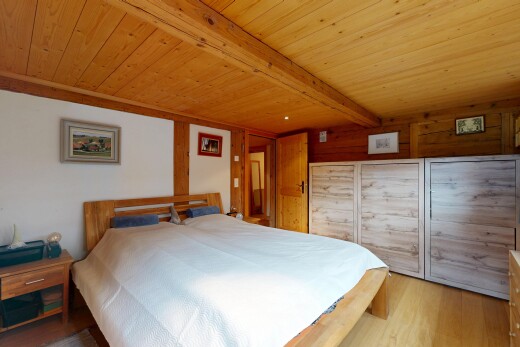 chambre avec sol en finition bois, wood finish floor, inside property, plafond à poutres, et beamed ceiling
