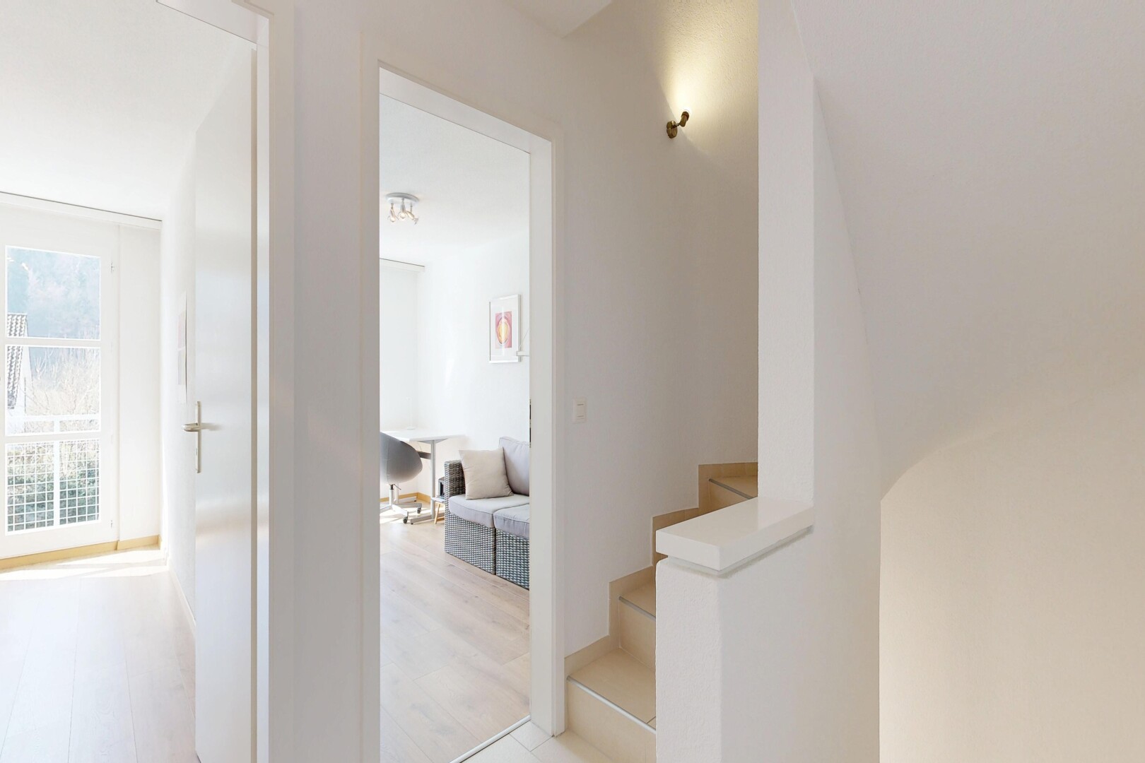 corridor featuring stairs and light wood-style floors