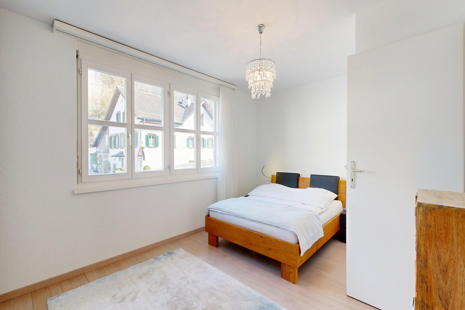 room / bedroom with light wood-style floors and hanging lights