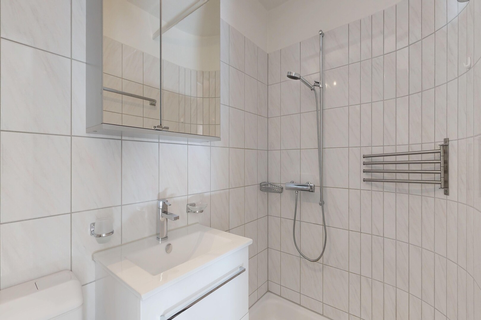 bathroom with vanity, a tile shower, tile walls, and a towel warming rack