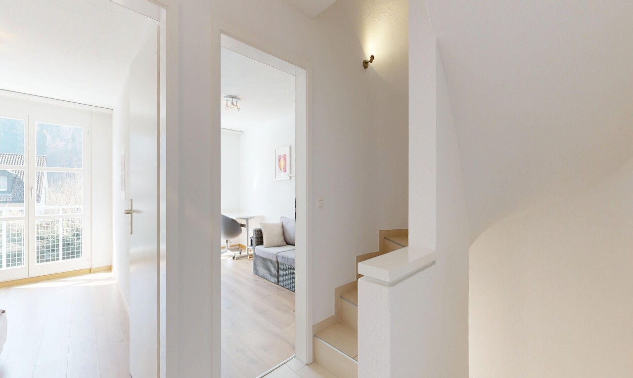 corridor featuring stairs and light wood-style floors