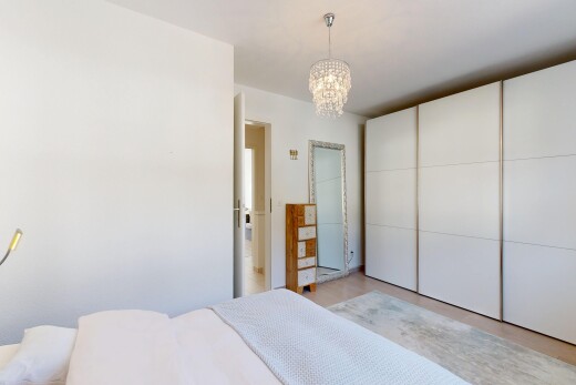 zimmer / schlafzimmer mit drywall, gipskartonwand, bemerkenswerter kronleuchter, inside property, und kleiderschrank