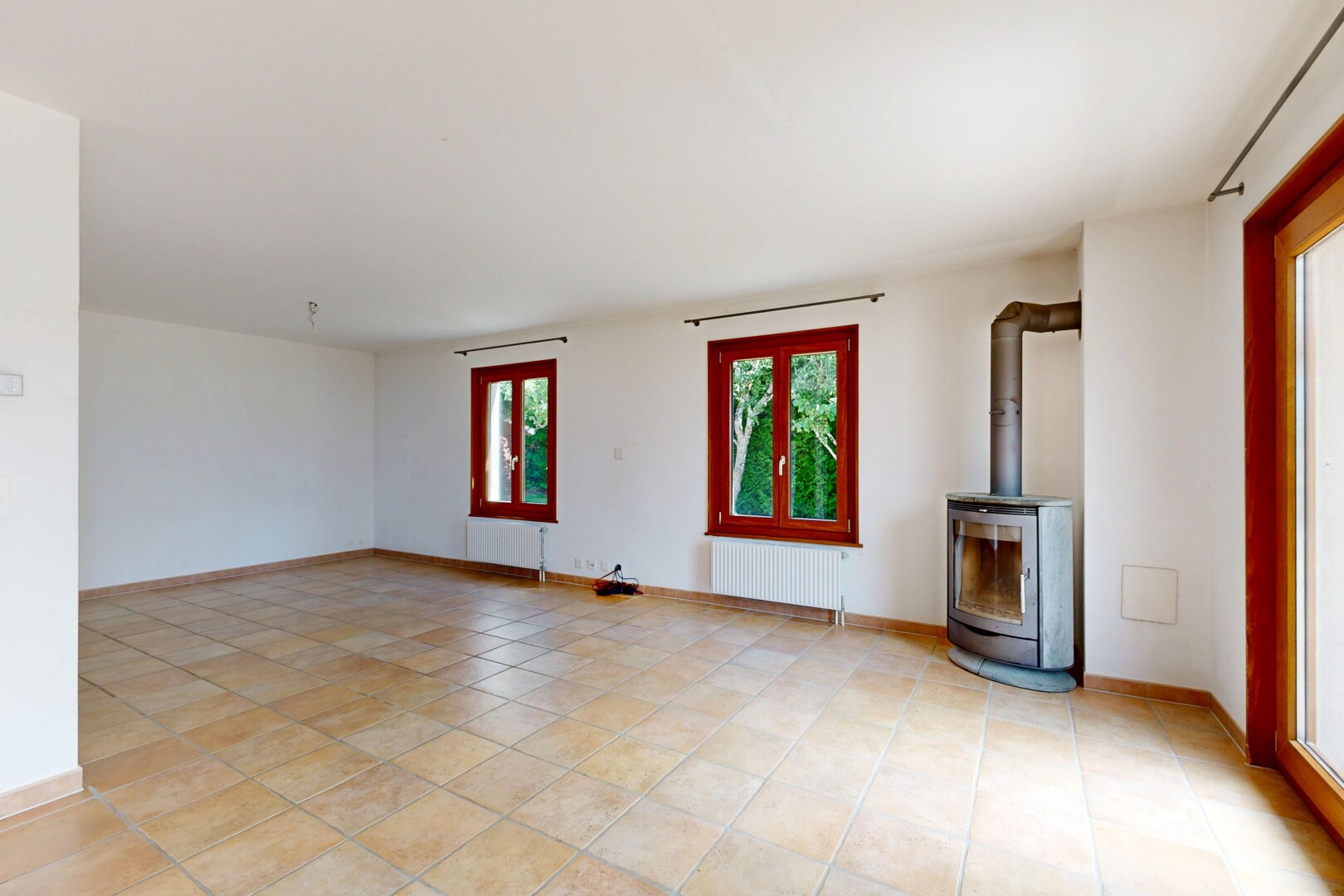 pièce vide avec poêle à bois, inside property, cloison sèche, drywall, et lumière naturelle