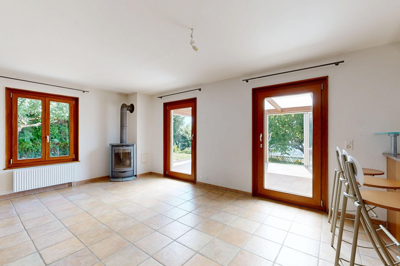 salon avec poêle à bois, radiateur, light floor, inside property, et cloison sèche