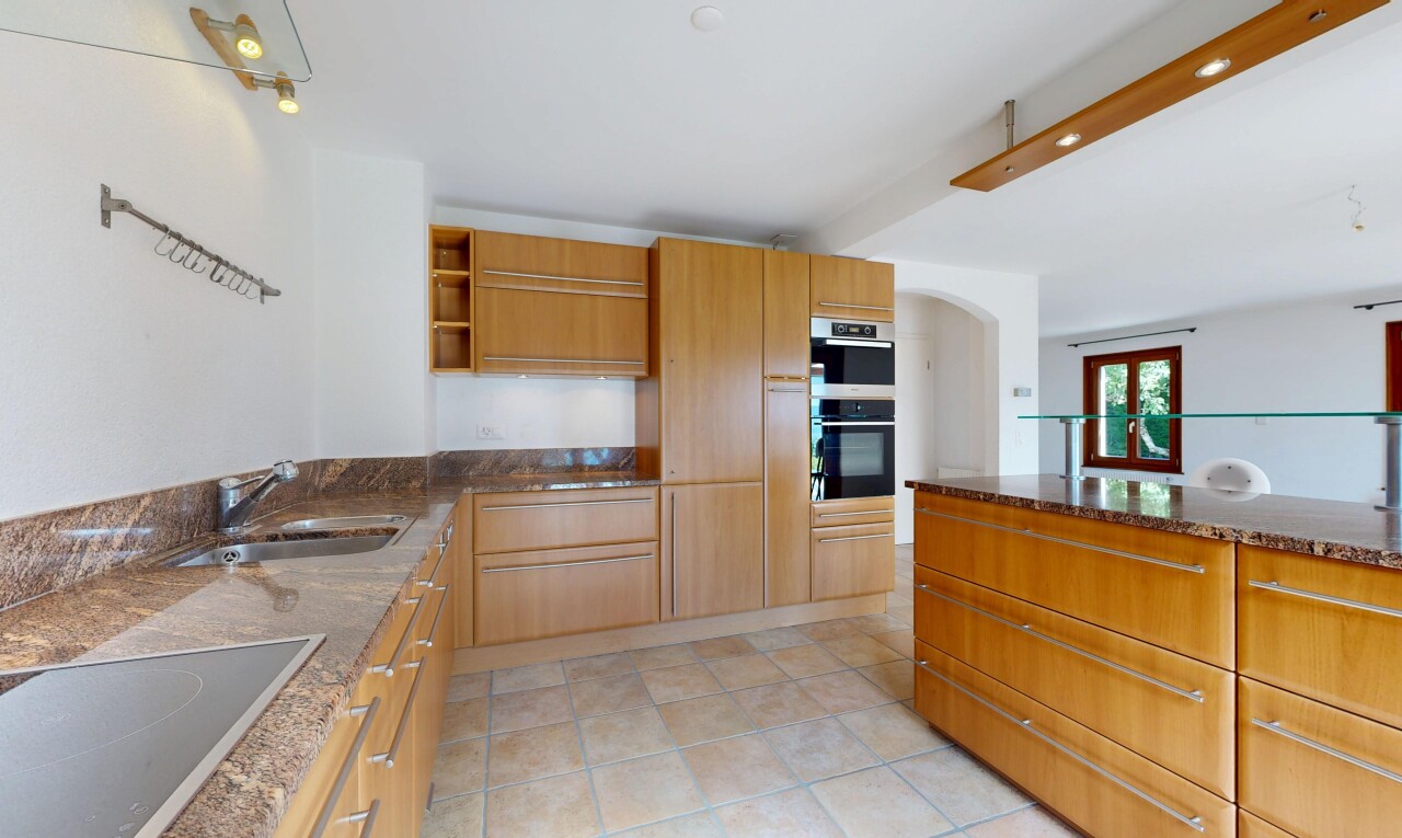 cuisine avec plans de travail en pierre, stone countertops, dark countertops, étagères ouvertes, et open shelves