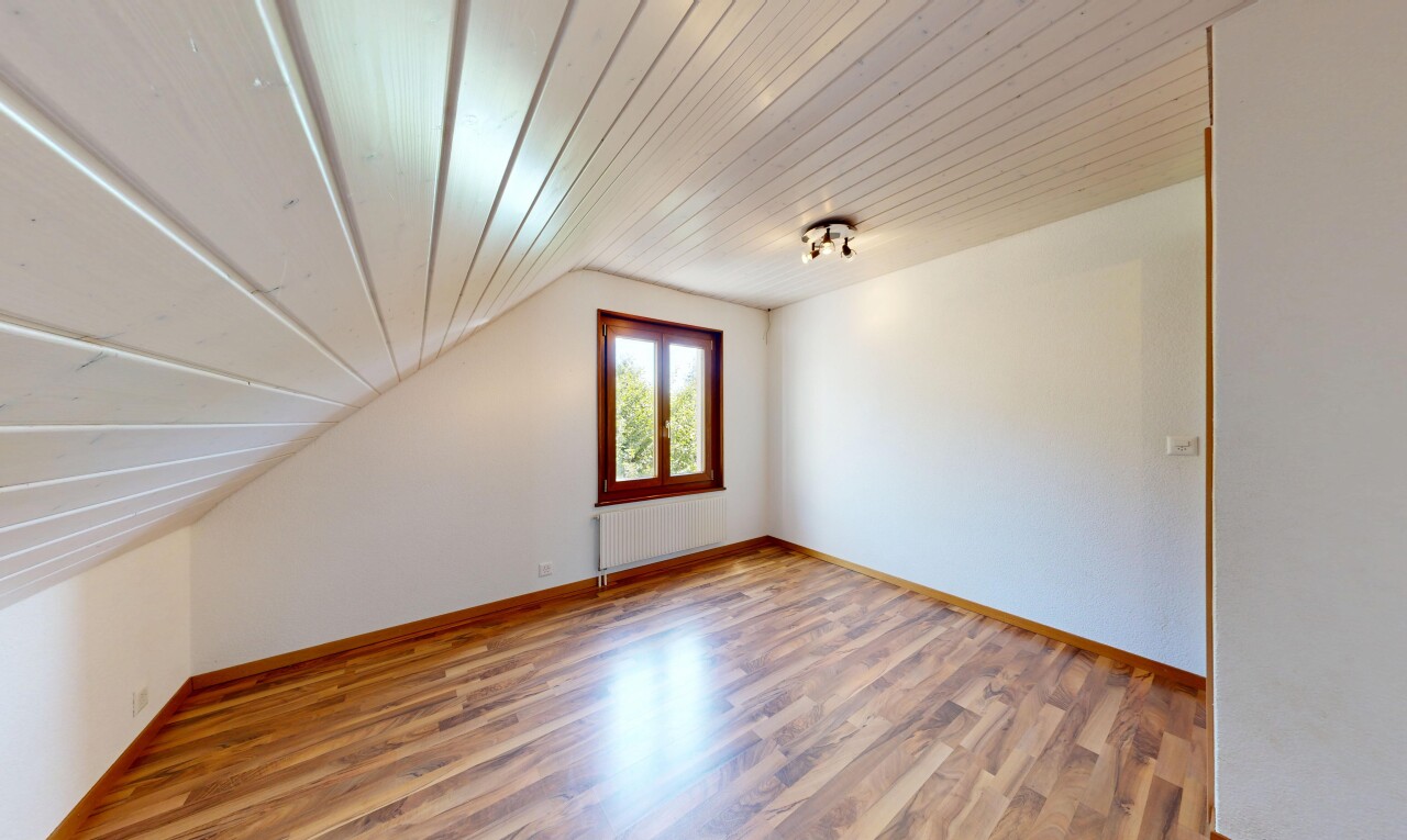 pièce vide avec sol en finition bois, wood finish floor, inside property, plafond voûté, et vaulted ceiling