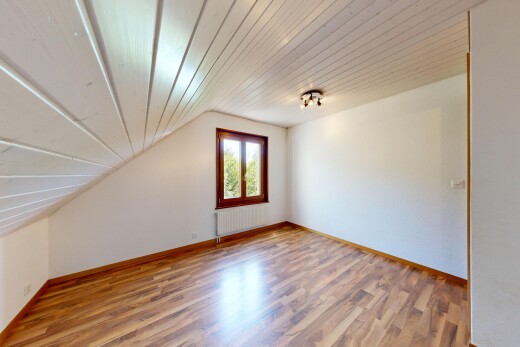 pièce vide avec sol en finition bois, wood finish floor, inside property, plafond voûté, et vaulted ceiling