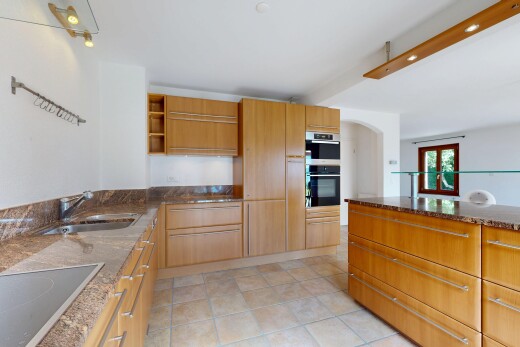 cuisine avec plans de travail en pierre, stone countertops, dark countertops, étagères ouvertes, et open shelves
