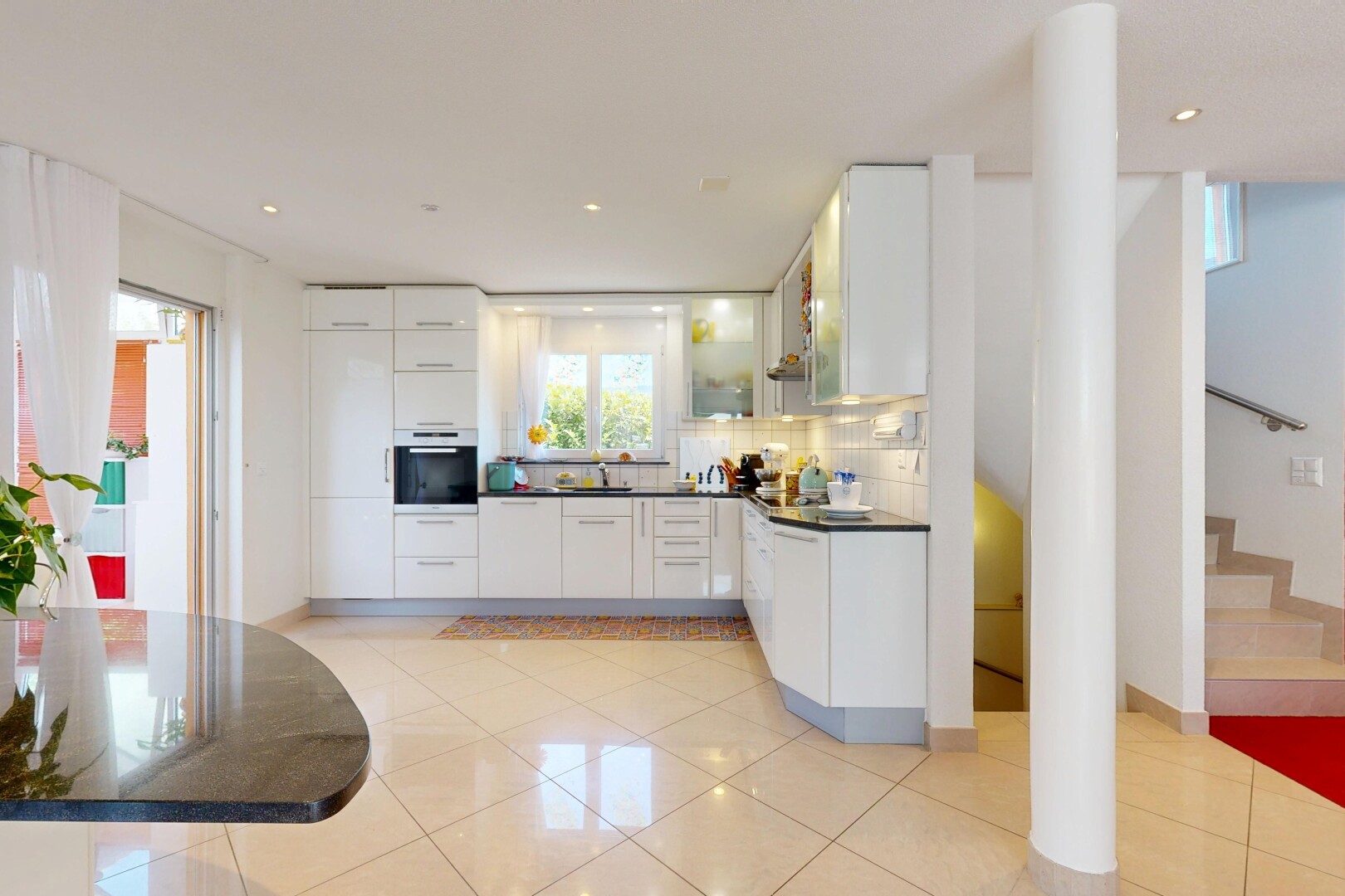 cuisine avec armoires blanches, white cabinets, dark countertops, four, et light floor