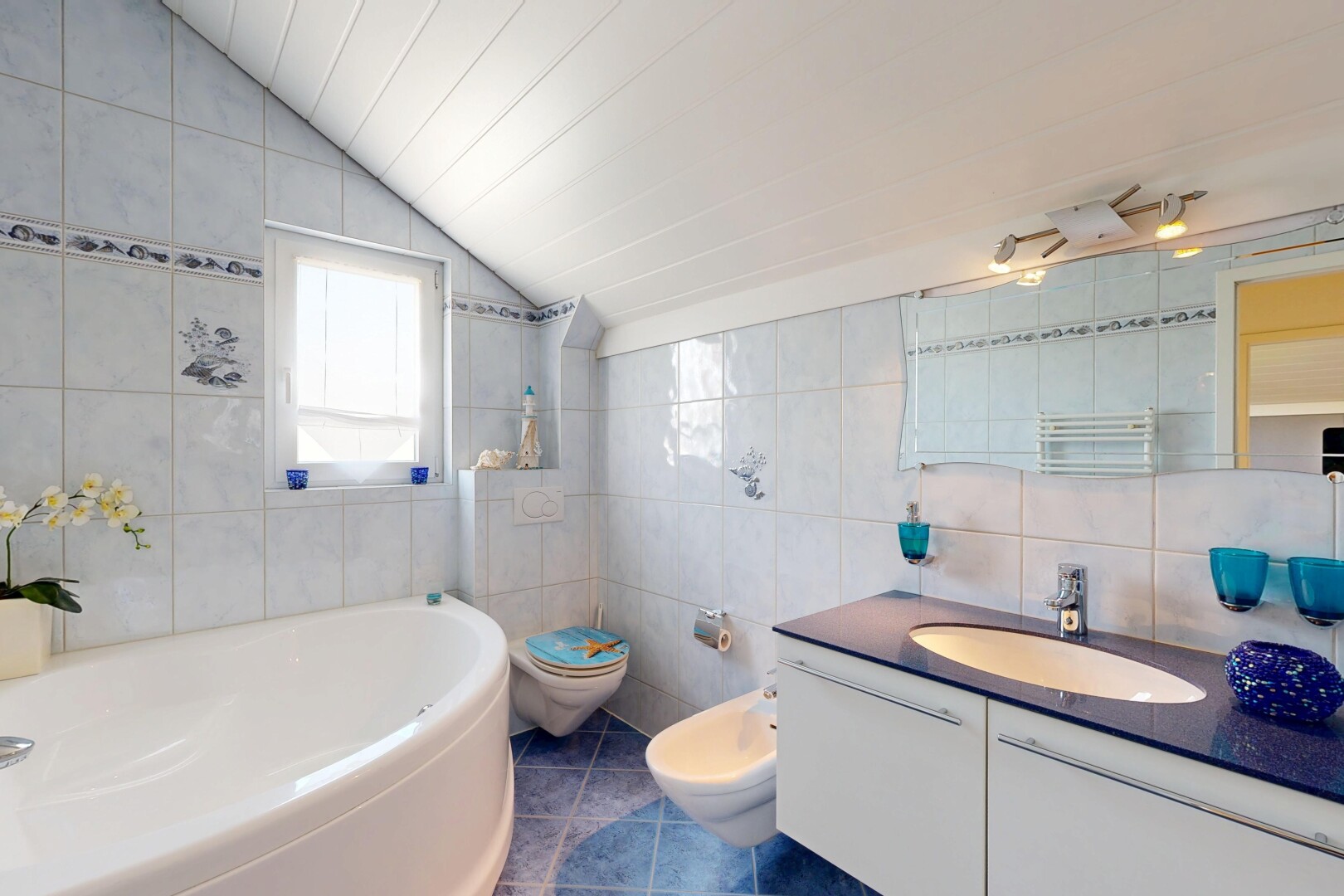 salle de bains avec mur en carrelage, tile wall, lavabo (ou coiffeuse selon le contexte), bain, et salle de bain complète