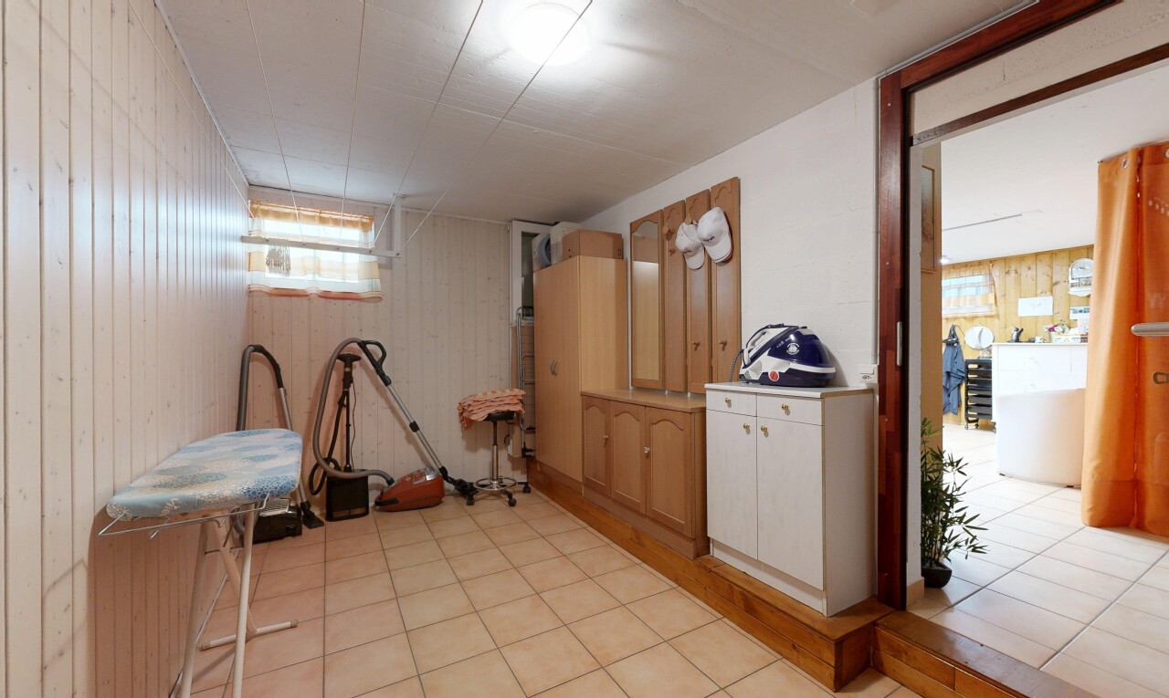 couloir avec mur en bois, wood wall, inside property, sous-sol, et light floor