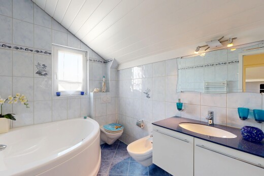 salle de bains avec mur en carrelage, tile wall, lavabo (ou coiffeuse selon le contexte), bain, et salle de bain complète