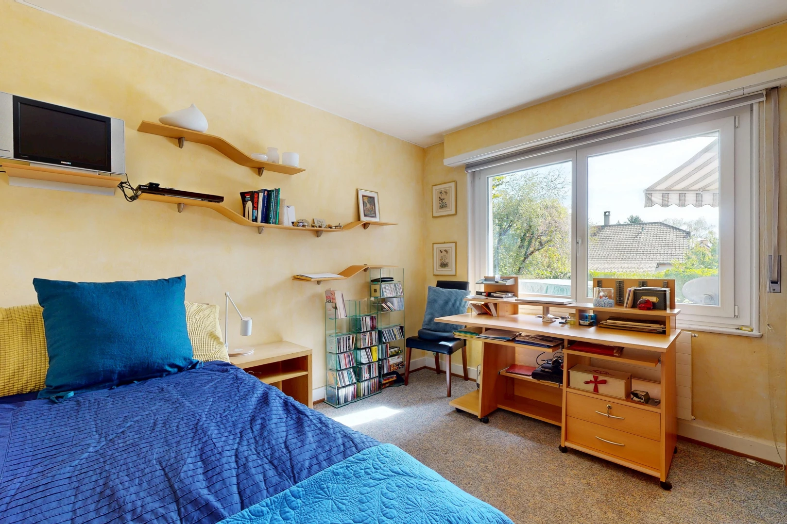 chambre avec télévision, carpet, moquette, drywall, et cloison sèche