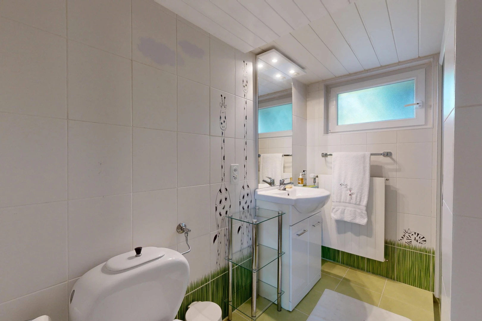 salle de bains avec tile wall, mur en carrelage, miroir, lavabo (ou coiffeuse selon le contexte), et évier