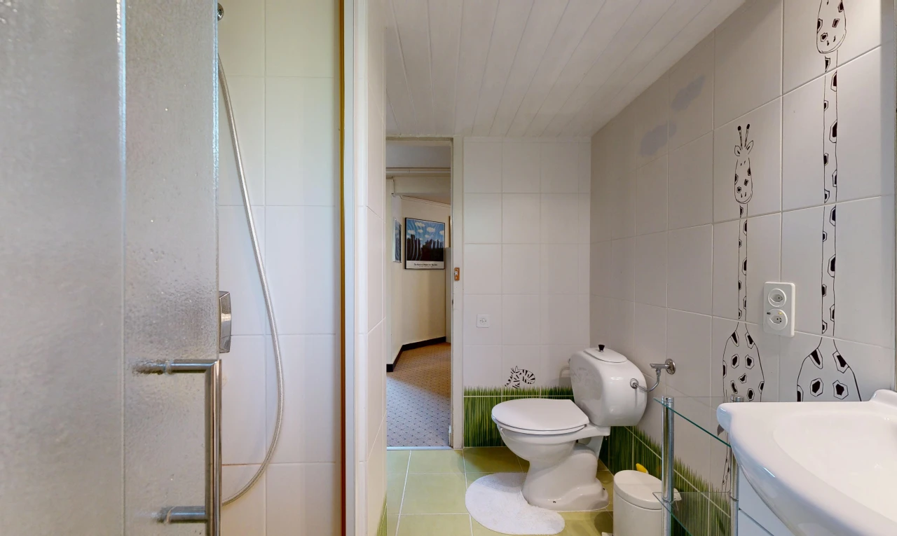 salle de bains avec salle de bain complète, tile wall, mur en carrelage, douche, et toilette