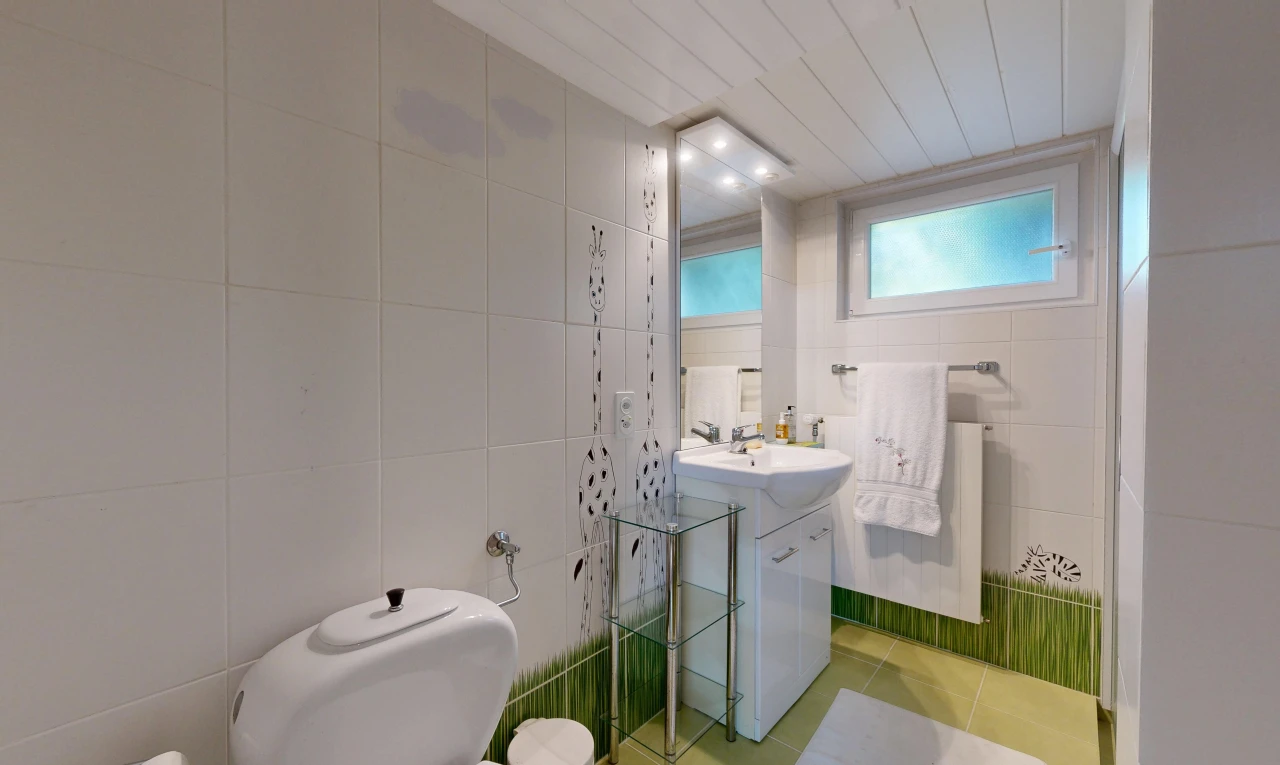 salle de bains avec tile wall, mur en carrelage, miroir, lavabo (ou coiffeuse selon le contexte), et évier