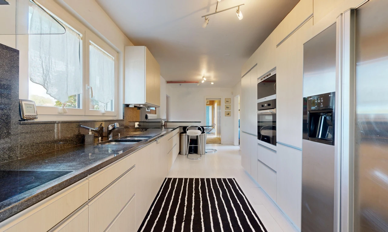 cuisine avec éclairage sur rail, réfrigérateur, dark countertops, light floor, et évier