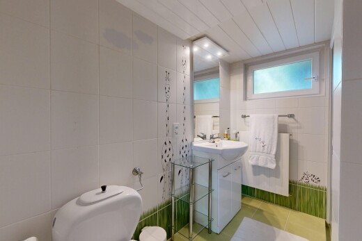 half bathroom with tile walls, vanity, radiator heating unit, and light tile patterned flooring