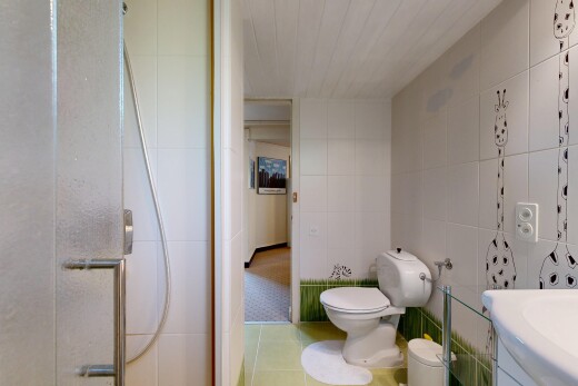 bathroom with tile walls, a shower, vanity, and light tile patterned flooring