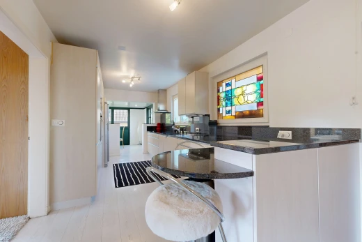 cuisine avec dark countertops, light floor, stone countertops, plans de travail en pierre, et inside property