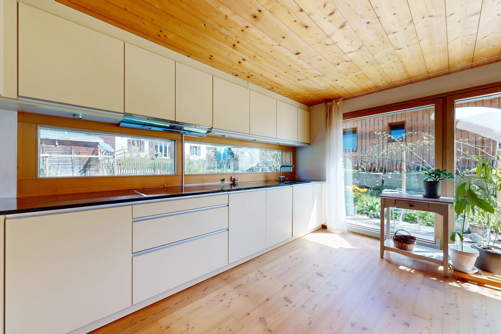 cuisine avec sol en finition bois, wood finish floor, plafond en bois, wood ceiling, et plans de travail