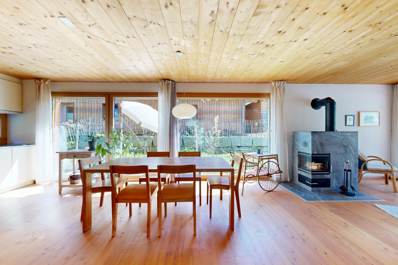 salle à manger avec poêle à bois, wood ceiling, plafond en bois, natural light, et lumière naturelle