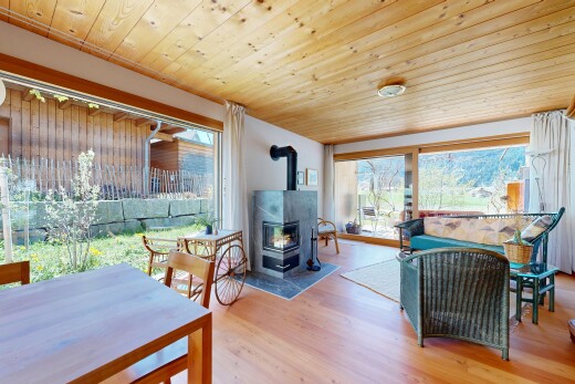 living room featuring wooden ceiling, a wood stove, and light wood-type flooring