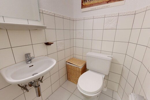 salle de bains avec toilette, sol en carrelage, tile floor, évier, et inside property