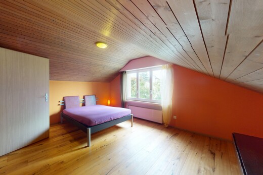 zimmer / schlafzimmer mit natürliches licht, natural light, holzfußboden, wood finish floor, und dachschräge