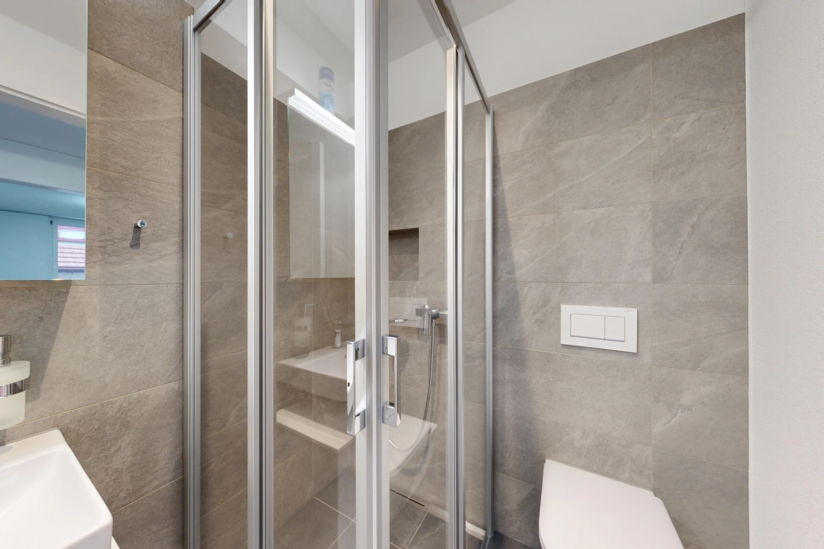 bathroom with a stall shower and tile walls