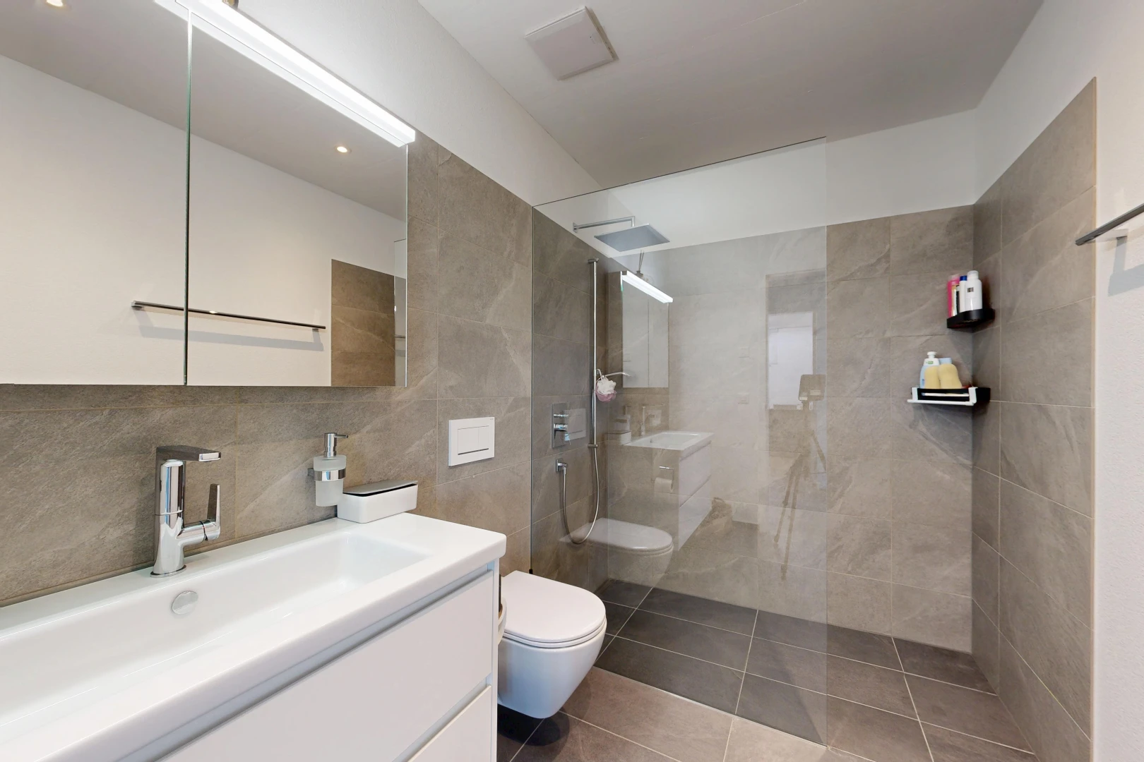 bathroom featuring a walk in shower, vanity, tile patterned floors, and tile walls