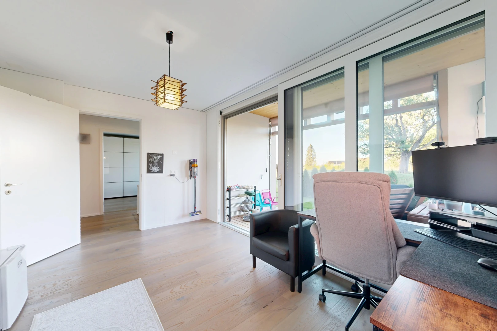 office with hanging light fixtures, access to exterior, and light wood-type flooring