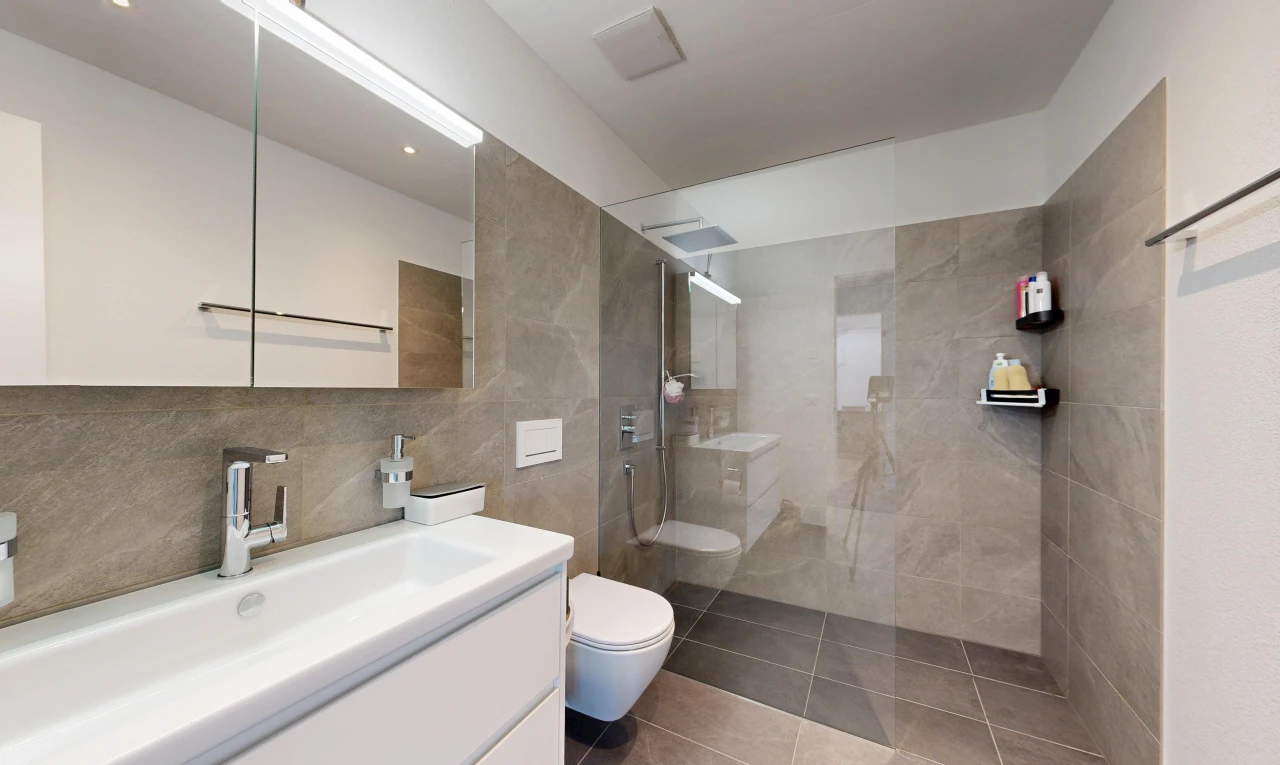 bathroom featuring a walk in shower, vanity, tile patterned floors, and tile walls