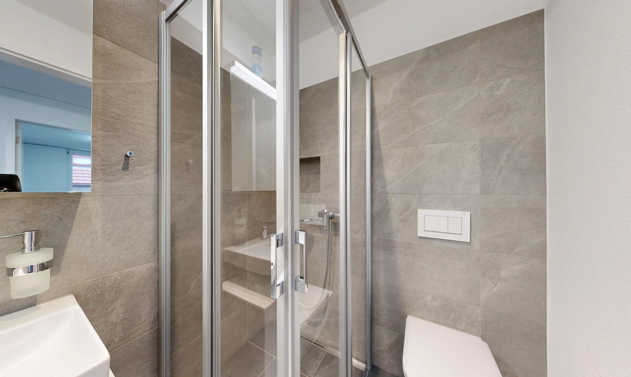 bathroom with a stall shower and tile walls