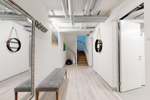 couloir avec escaliers, cloison sèche, drywall, sous-sol, et sol en finition bois