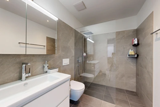 bathroom featuring a walk in shower, vanity, tile patterned floors, and tile walls