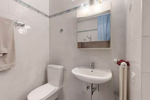 salle de bains avec vasque, mur carrelé, et miroir