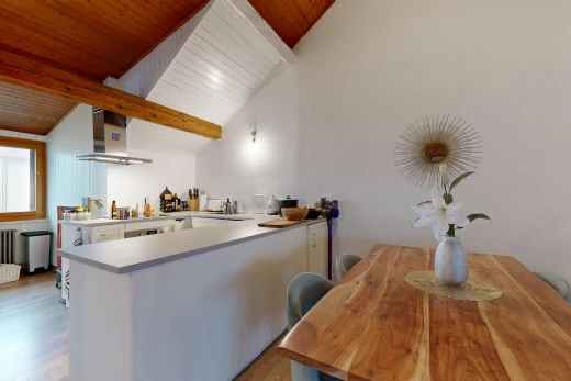 cuisine avec plafond voûté, hotte, poutres apparentes, plan de travail, et plancher de bois