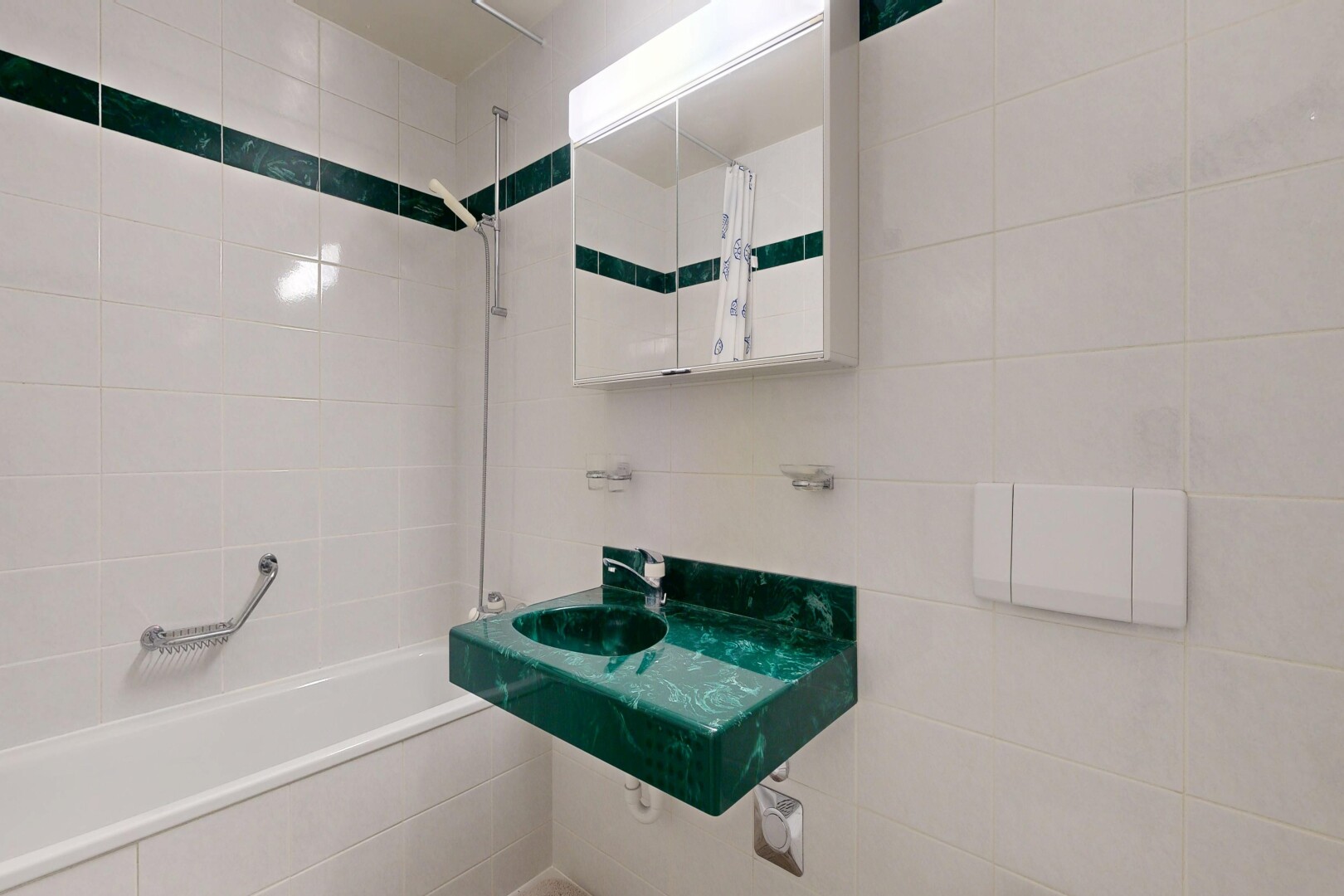 bathroom featuring tiled shower / bath combo, vanity, and tile walls
