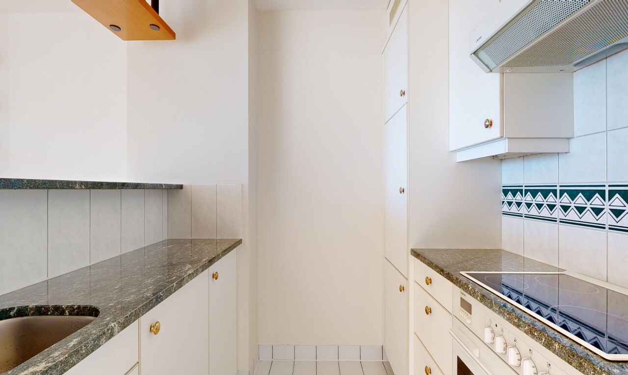 kitchen with backsplash, exhaust hood, white cabinetry, and wall oven