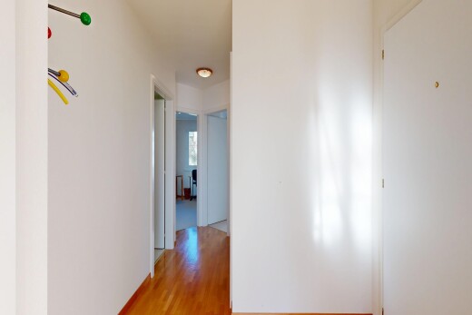 couloir avec cloison sèche, drywall, sol en finition bois, wood finish floor, et inside property