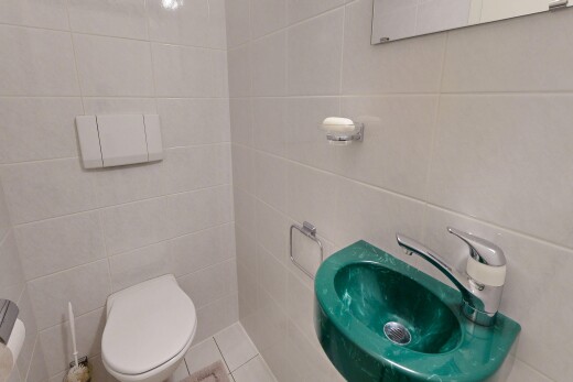 salle de bains avec mur en carrelage, tile wall, toilette, évier, et inside property