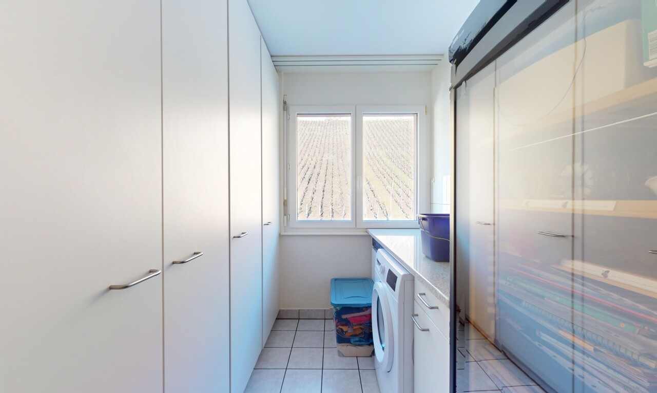 buanderie avec machine à laver / sèche-linge, lumière naturelle, et carrelage